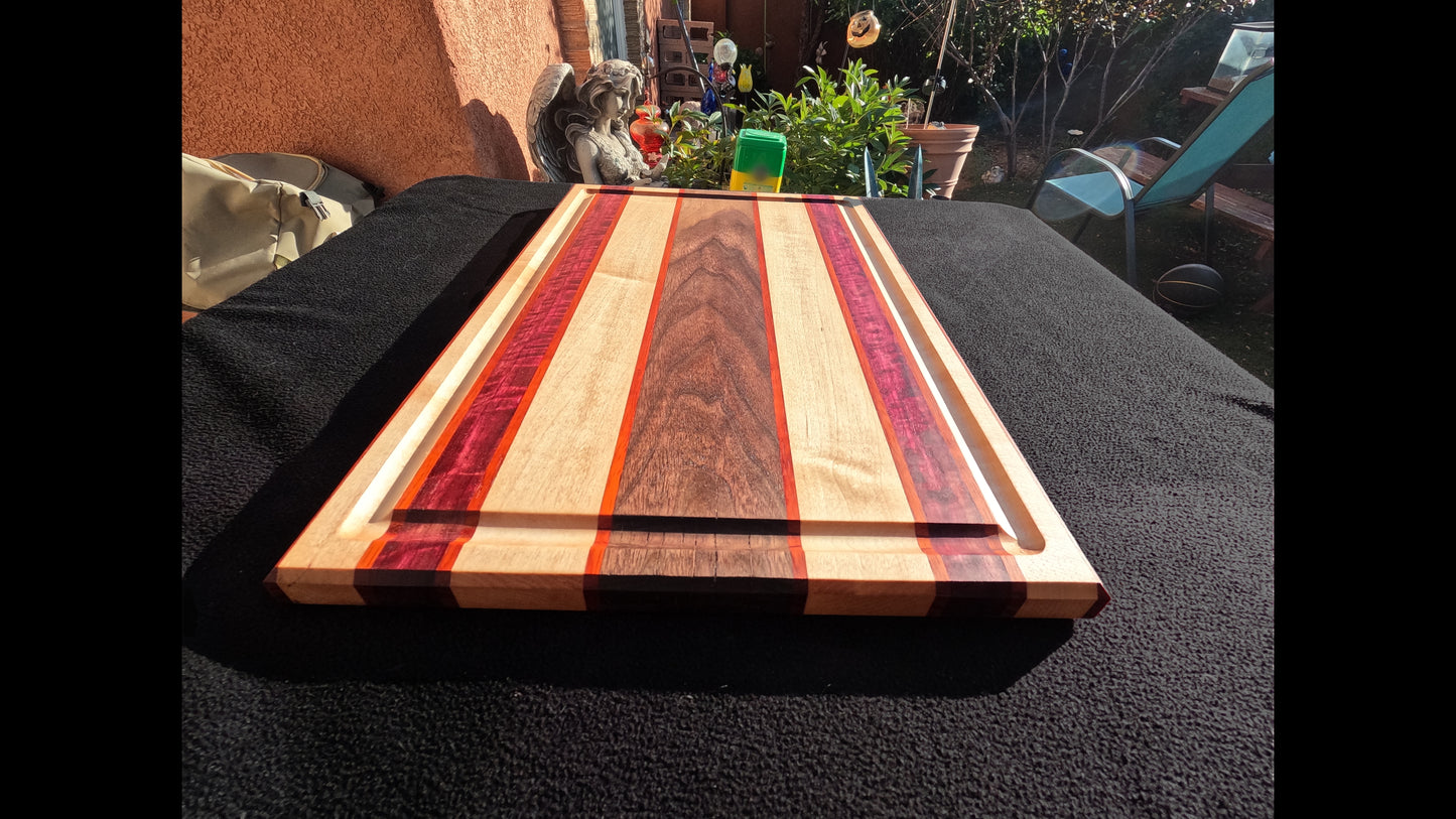 Lower front view of the Slice of life cutting board with striped pattern, featuring Maple, walnut, purple heart, and padauk hardwoods.