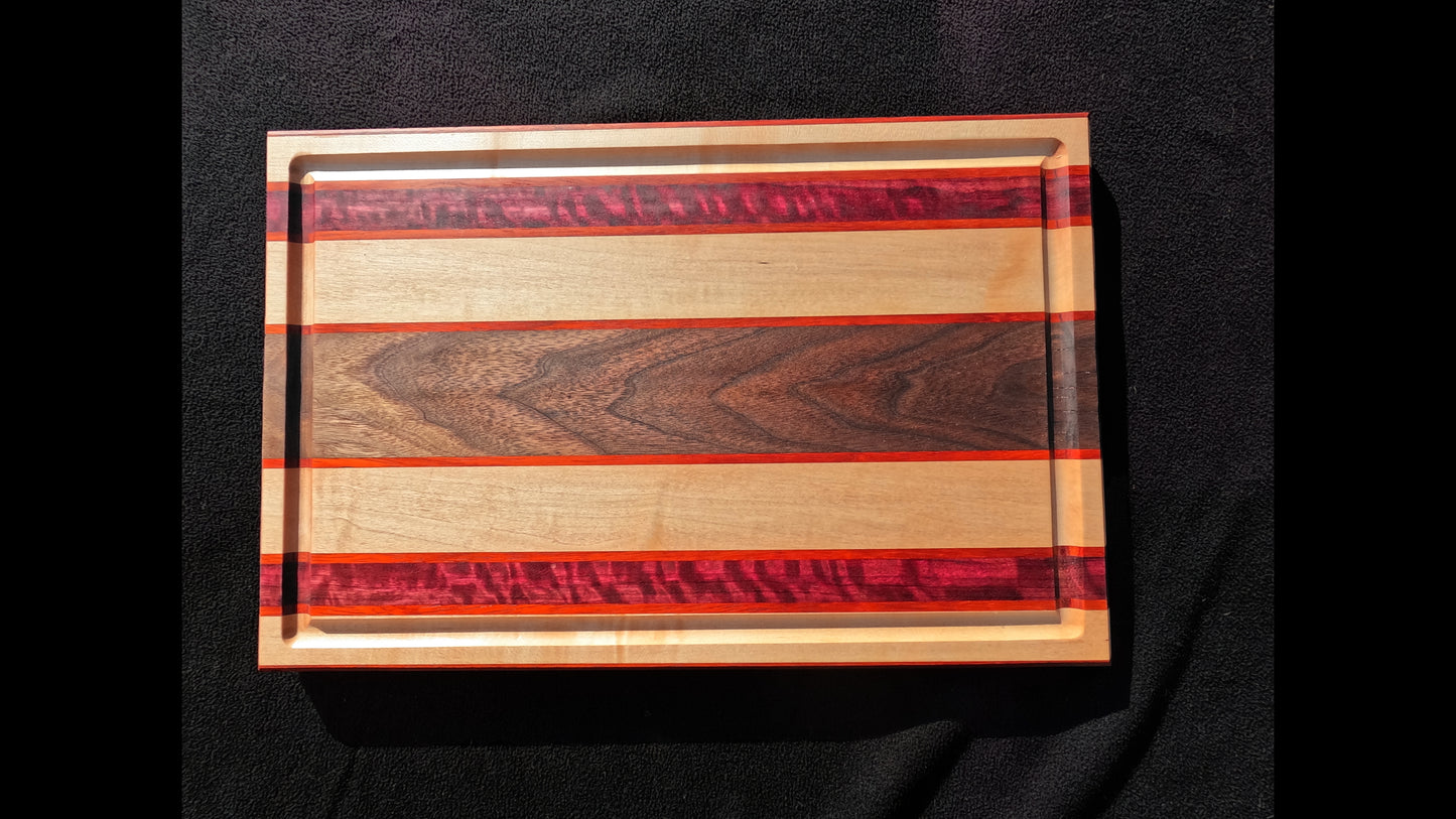 Front Top view of the Slice of life cutting board with striped pattern, featuring Maple, walnut, purple heart, and padauk hardwoods.