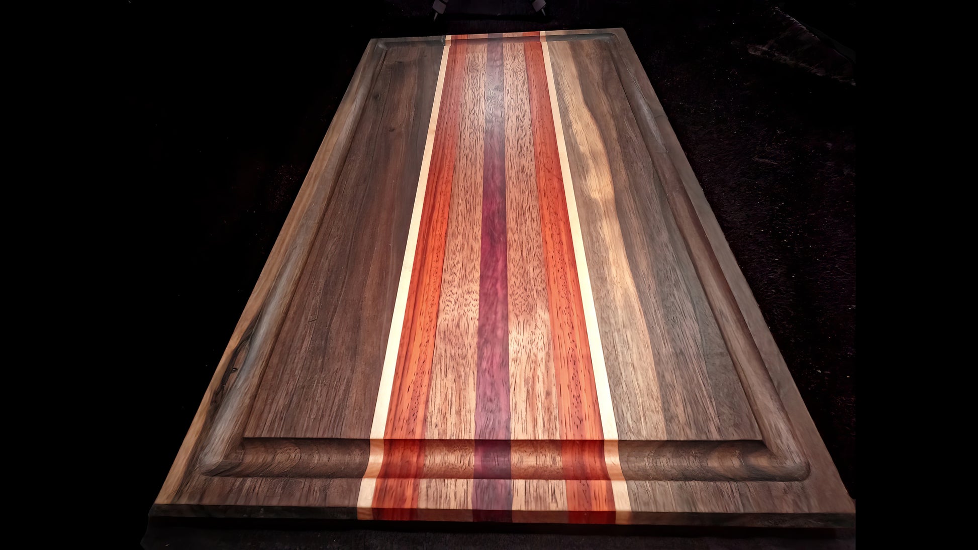 lower front view of the Board to death stripped pattern Cutting board, featuring Walnut, maple, padauk, African mahogany, and purple heart hardwoods.